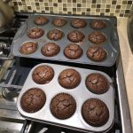 chocolate muffins straight out of the oven in muffins tins sitting on top of gar stove range