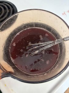 whisking of gummy mixture juice in glass pot over stovetop