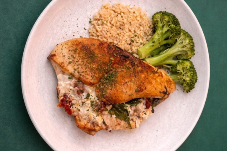 stuffed chicken breast on plate with broccoli and brown rice
