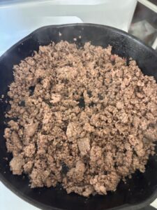 browning the beef in a cast iron pan on the stovetop