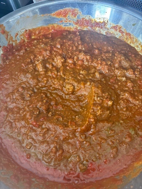 Large steel bowl of marinara and meat mixture