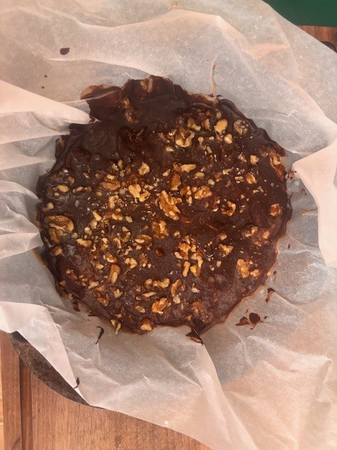 Ingredients for Healthy Snickers Bars frozen and set in round baking pan lined with parchment paper