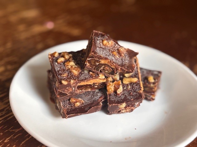 homemade date bark on small white plate on rustic table