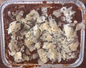 aluminum pan containing all ingredients for the hidden vegetable meat lasagna ready to be baked in oven