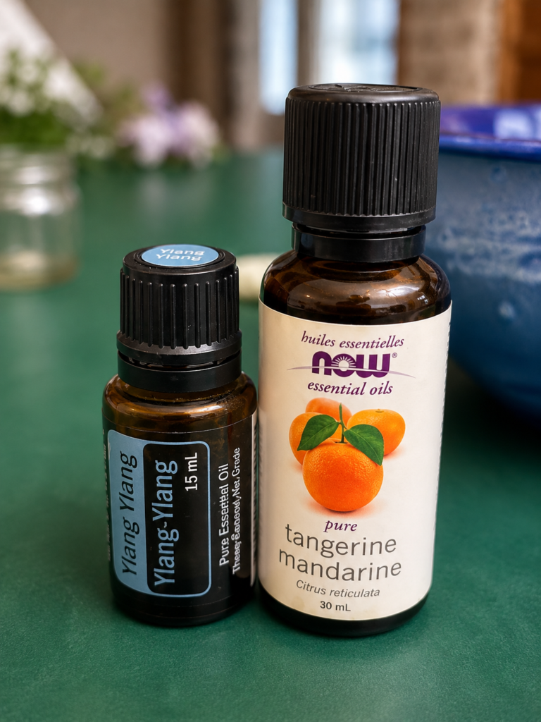Two different sized amber bottles of essential oils sitting on green kitchen counter